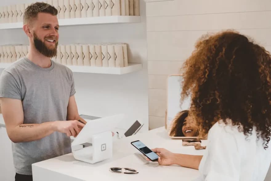 Kundin bezahlt mit dem Smartphone an der Ladenkasse – Online-Shop und E-Commerce