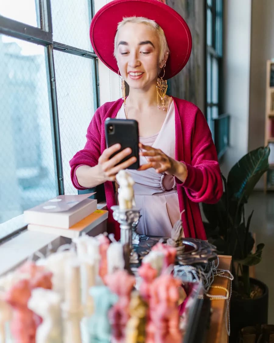 Inhaberin fotografiert ihre handgemachten Kerzen mit dem Smartphone – eigene Fotos für die Website