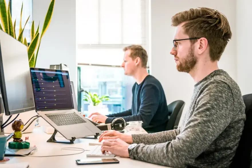 Zwei Entwickler arbeiten an ihren Computern – individuelle Web-App entwickeln lassen