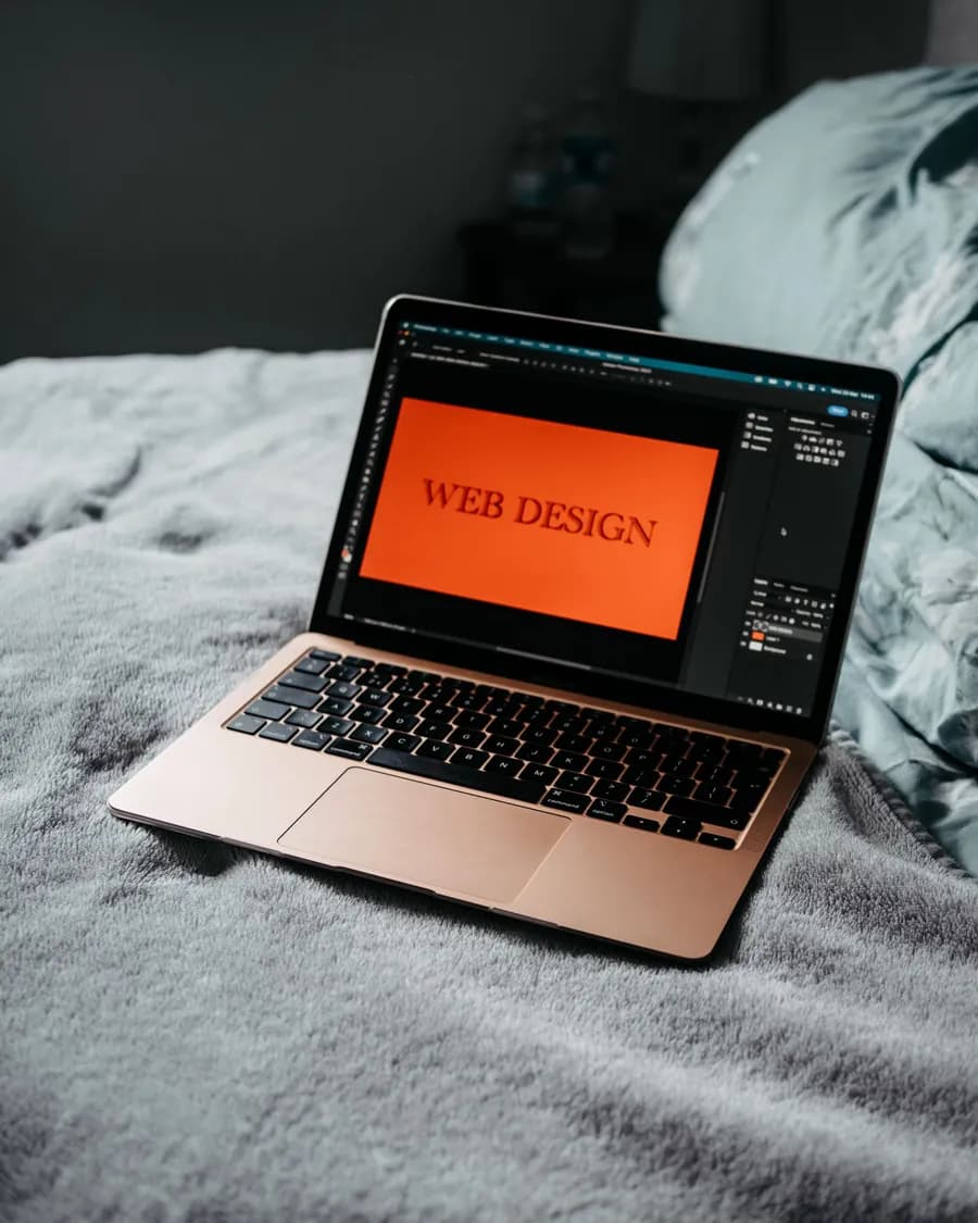 Laptop mit dem Schriftzug „Web Design“ auf dem Bildschirm – professionelle Website erstellen lassen